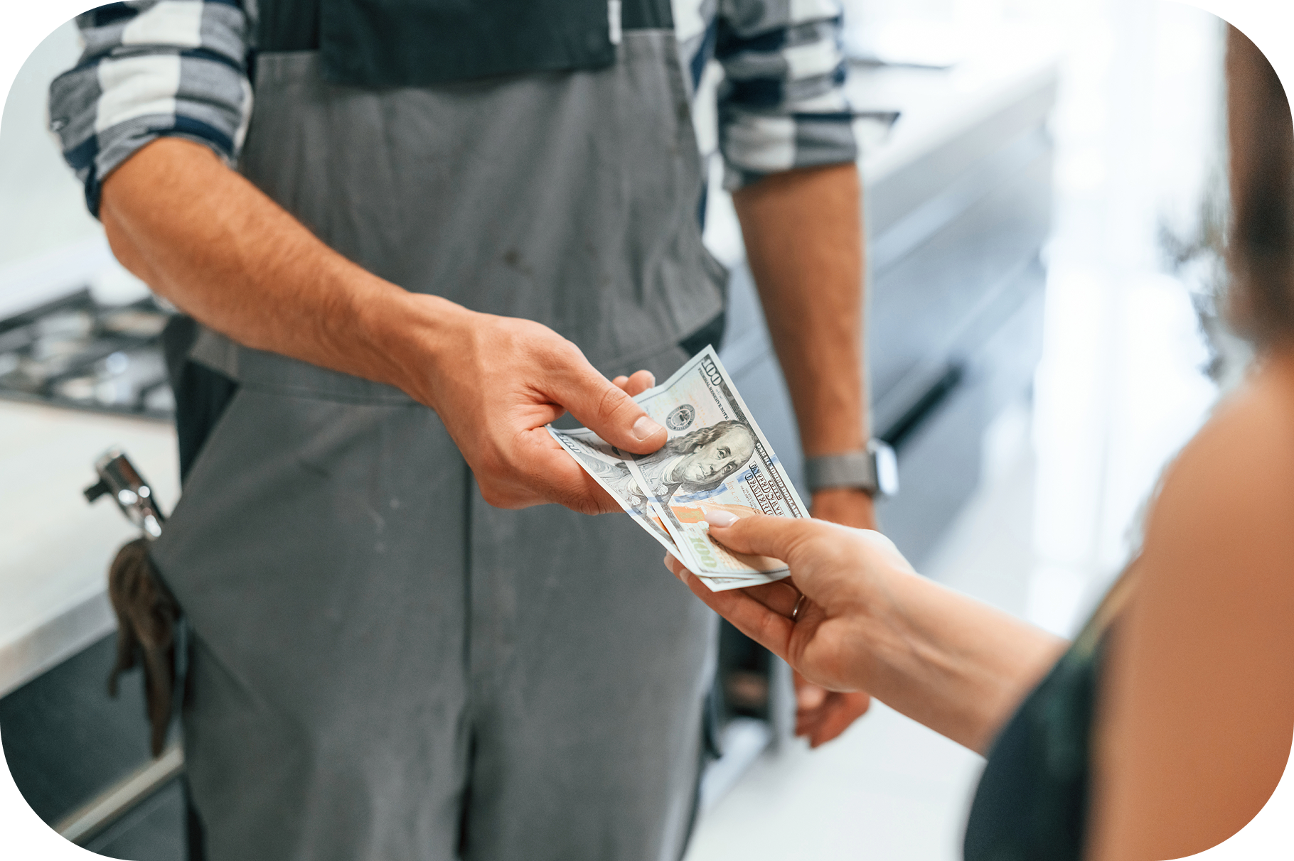 Homeowner giving cash to a plumber to show costly fixes from poor water quality.